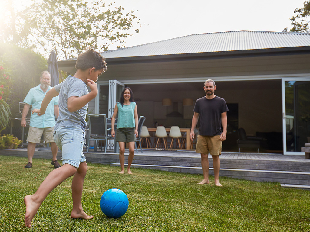 a child and three adults play football