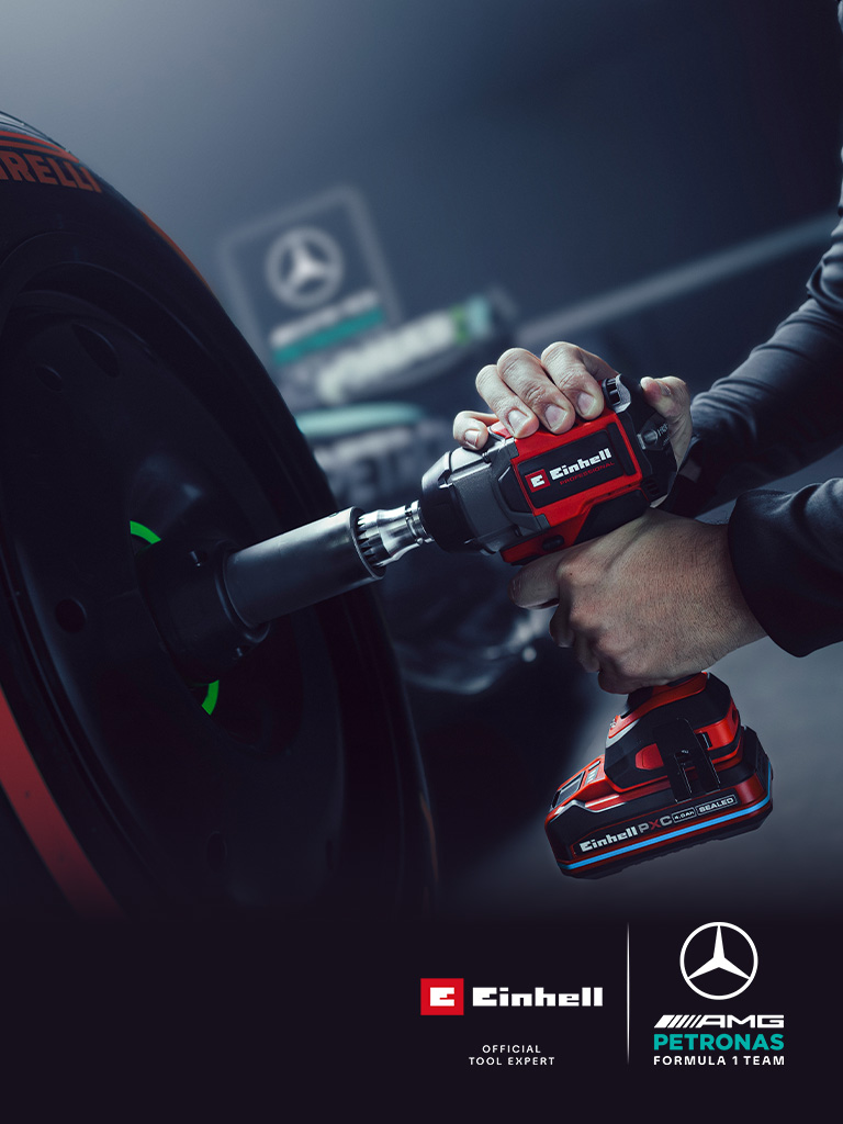 Einhell akumulatorski udarni odvijač u upotrebi na kotaču automobila, s oznakama i logotipom partnerstva Mercedes-AMG Petronas Formula One tima