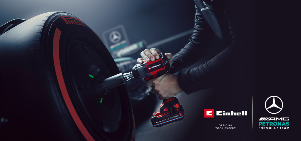 Einhell akumulatorski udarni odvijač u upotrebi na kotaču automobila, s oznakama i logotipom partnerstva Mercedes-AMG Petronas Formula One tima