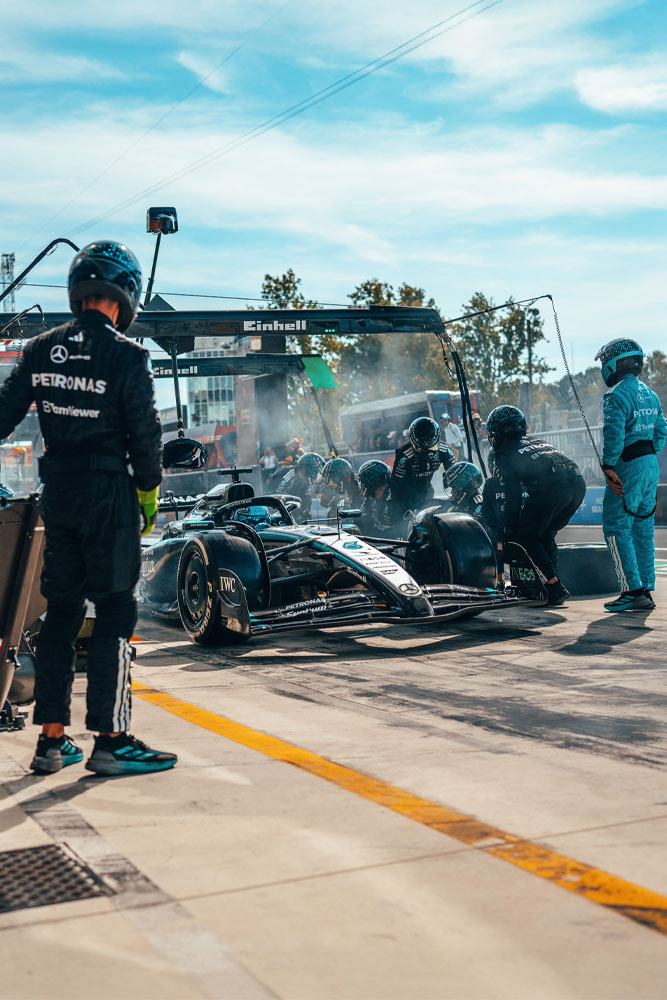 Intenzivno zaustavljanje u boksu za Mercedes-AMG PETRONAS Formula One tim. Tim je u akciji, mijenja gume i provjerava automobil ispod portala s Einhell oznakom.