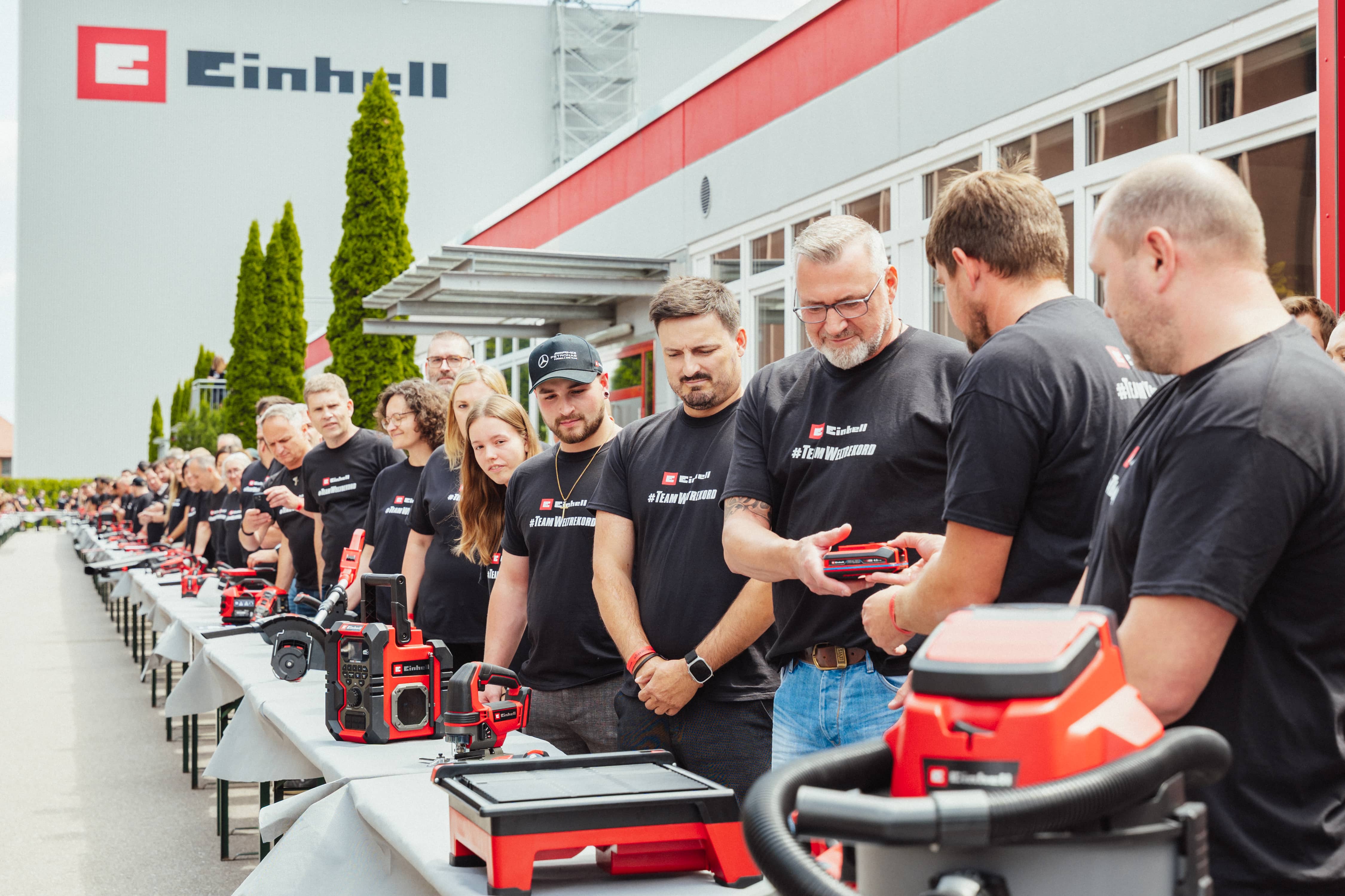 Einhell staff stand by tables with tools and hand over a SEALED battery.