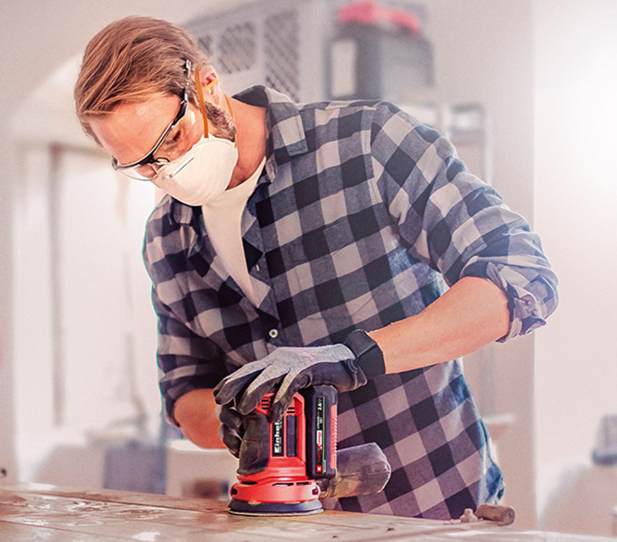 man working with a cordless rotating sander