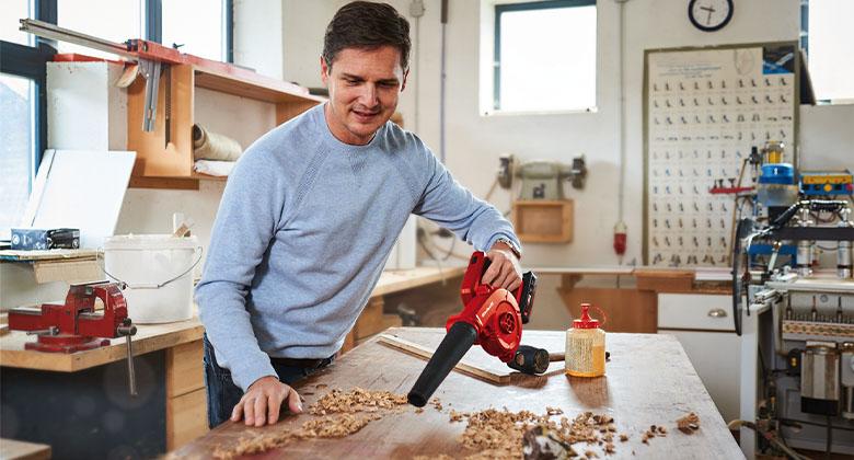 man working with leaf blower in a workshop