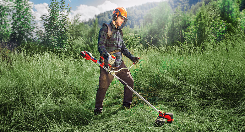 man working with a cordless scythe
