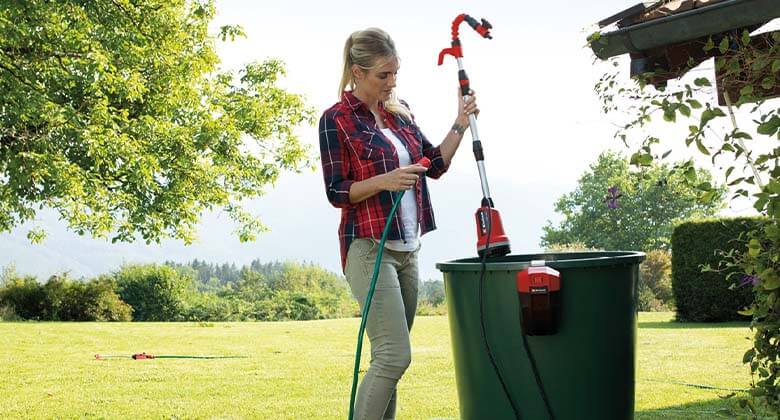 woman using a rain barrel pump