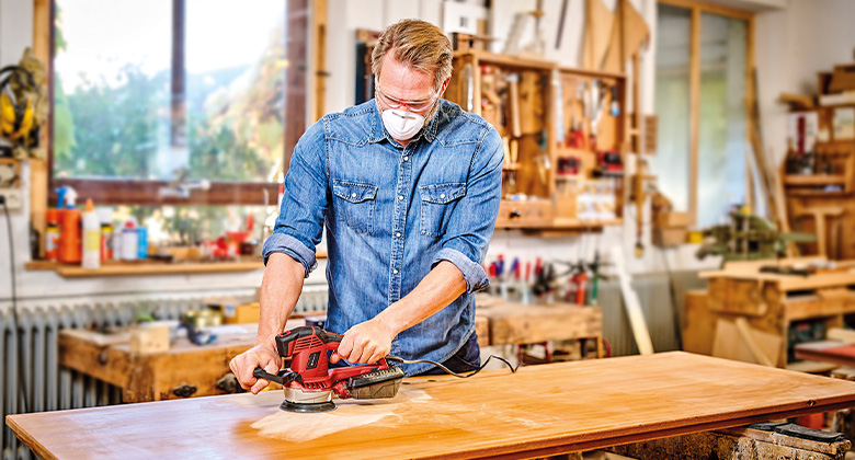 man using grinder for sanding wood